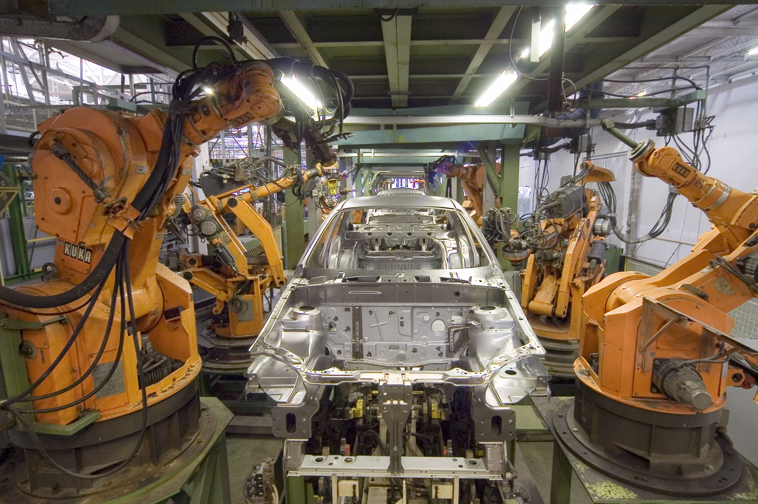 自動車車体の周囲で稼働するKUKAの産業用ロボット
